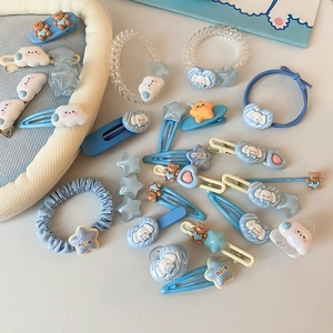 Vue à plat d'un ensemble de barrettes et chouchous bleu clair sur fond blanc