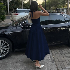Detailansicht des rückenfreien Designs und Neckholders am dunkelblauen Maxikleid