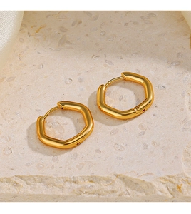 Dettaglio degli orecchini esagonali placcati oro 18 carati su seta e pietra beige