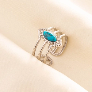 Close-up of vintage silver multi-layer open ring with turquoise stone on beige fabric