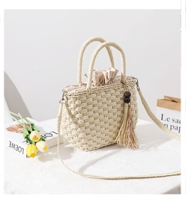Detail of straw bag with wooden bead tassels and drawstring lining on a textured surface
