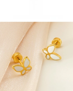 Détail de boucles d'oreilles papillon en or 18K avec émail blanc et finition polie