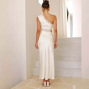 Détail d'une robe longue en satin blanc avec coutures en dentelle et dos nu élégant