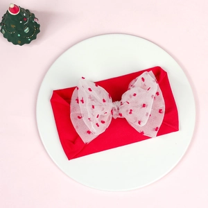 Close-up of red elastic headband with large mesh bow featuring delicate heart patterns