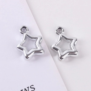Macro shot of two polished silver star charms with top holes for DIY jewelry making