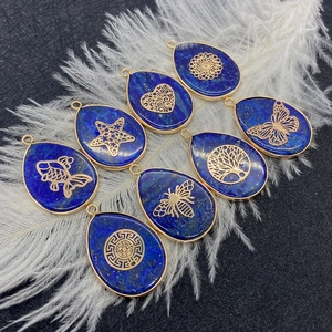 Lapis lazuli drop pendants with gold filigree patterns on a white feather