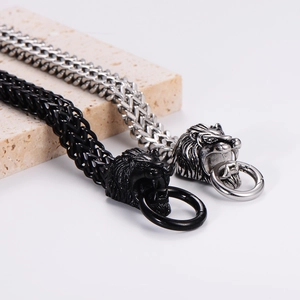 Rugged stainless steel lion head bracelets in silver and black on textured stone