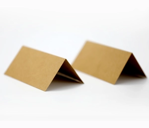 Detail view of brown kraft paper folding place cards in a minimalist tent-style arrangement