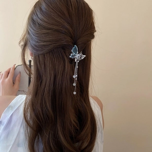 Détail d'une pince à cheveux papillon argentée avec pampilles de perles