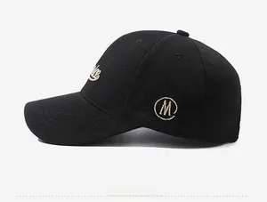 Detail of high-density black cotton baseball cap showing side M embroidery and stitching