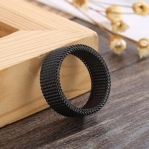 Macro view of matte black mesh titanium steel ring on minimalist wooden background