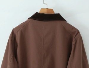 Close-up of the vintage brown jacket featuring a corduroy collar and cotton canvas fabric