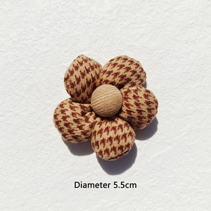 Close-up of a 5.5cm houndstooth fabric flower accessory with central button detail
