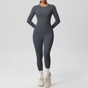 Détail d'un ensemble de yoga gris anthracite avec haut à manches longues et legging serré