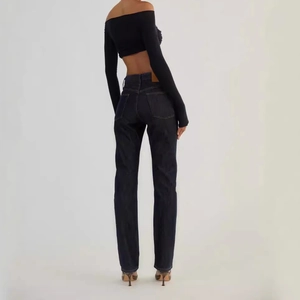 Rear view of slim fit high waisted denim jeans in dark blue on model with black top