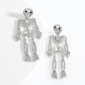 Gothic silver skull earrings with white rhinestones and black crystal eyes on a pedestal