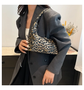 Detailed view of large leopard print bucket bag styled underarm with a casual blazer