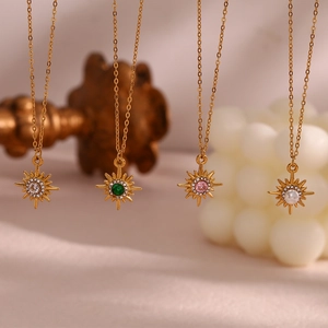 Detailed view of four 18K gold plated necklaces featuring starburst zircon pendants