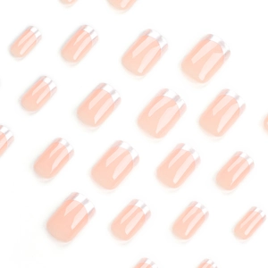 Faux ongles français rose nude avec bords métalliques argentés sur fond blanc épuré