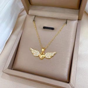 Detail of gold heart necklace with winged pavé diamonds in a luxury jewelry gift box