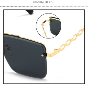 Detail of gold metal hinges and hollow chain temples on rimless sunglasses