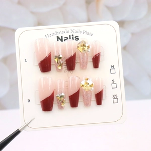 Detailed view of handmade cherry red French press-on nails with sparkling rhinestones