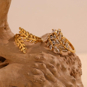 Detalle de anillos de rama chapados en oro 18K con diamantes marquise sobre madera