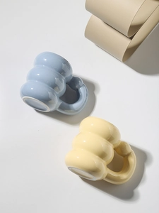 Top view of two colorful ceramic mugs with wavy bodies and chunky handles