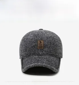 Detail of grey winter baseball cap with leather logo patch and thick textured fabric