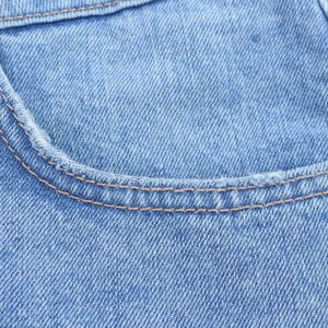 Detailed close-up of blue denim pocket edges featuring durable double-stitch sewing