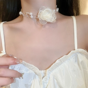 Close-up of white mesh flower choker with pearls and invisible line on model's neck