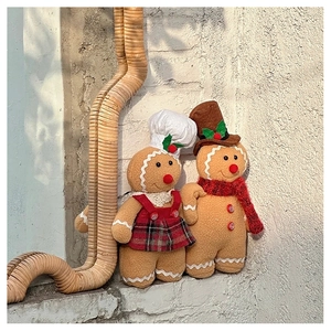 Macro detail of plush gingerbread man couple with chef hat and scarf for Christmas decor
