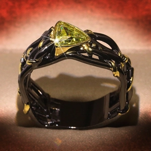 Two-tone black and gold ring featuring a triangle yellow topaz gemstone centerpiece