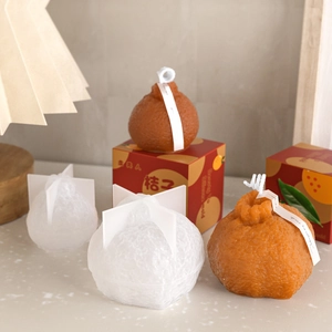 Detaillierte Fruchttextur der Orangenkerze mit festlicher Geschenkverpackung