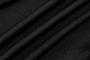 Detailed macro view of black high-quality knitted fabric with subtle diagonal texture