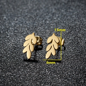 Macro shot of gold leaf stud earrings measuring 13mm by 6mm on a black texture