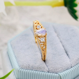 Macro shot of pear-shaped moonstone vintage ring on light blue velvet display