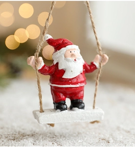 Detail of Santa Claus on a swing hanging ornament with festive red suit and rope