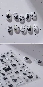 Close-up of black cartoon cat nail art stickers with stars and hearts on a sheet