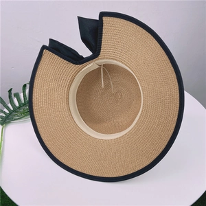 Détail d'un chapeau de paille d'été avec nœud et design ouvert pour queue de cheval