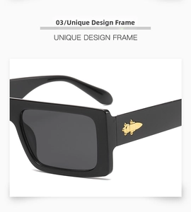 Detail of black rectangular sunglasses with gold bullet-shaped metal temple decor