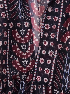 Close-up of paisley print fabric on V-neck blouse with blue and red patterns