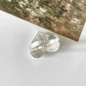 Macro shot of S925 sterling silver heart ring with adjustable band on artistic background