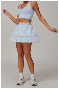 Detailed view of light blue lace yoga top and tiered sports skirt with floral textures