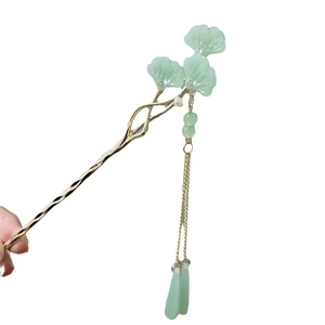 Traditional green ginkgo leaf hair pin with golden tassel and pearls on white backdrop