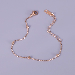 Close-up of rose gold beaded titanium steel bracelet with K18 tag and adjustable chain