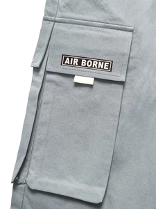 Detail der hellgrauen Cargohose mit großer Seitentasche und AIR BORNE gewebtem Etikett