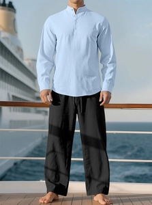 Detail of light blue linen shirt with mandarin collar and black joggers on cruise deck