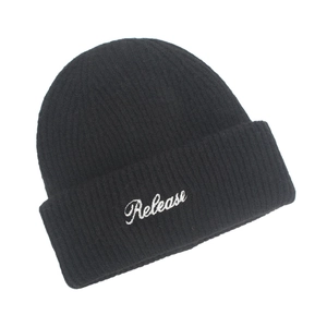 Close-up of Release embroidery detail on a warm black knitted beanie for winter