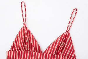 Détail de la robe à rayures rouges et blanches avec fines bretelles et col en V